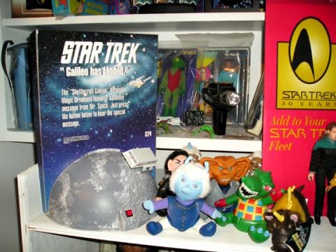 1984 Pontiac Fiero - A collection of Star Trek merchandise, including an ornament box and various action figures, displayed on a shelf.