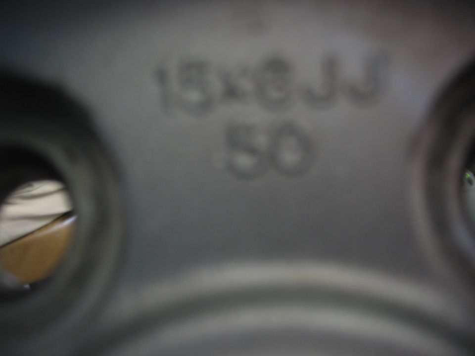 Close-up of steel wheel stamped 15x6JJ 50, showing rim size and offset markings