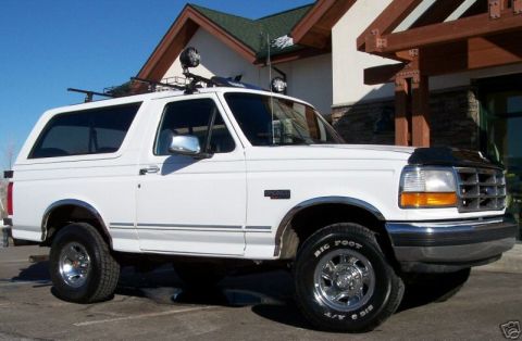 1994 Ford Bronco - This white 1994 Ford Bronco is equipped with a roof rack and auxiliary lights, suggesting it's ready for adventure.