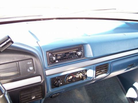 1994 Ford Bronco - Interior view of a blue dashboard, showing the radio and climate controls, with visible signs of use.