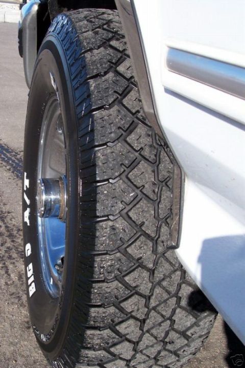 1994 Ford Bronco - Close-up of a white SUV's tire, showing the tread pattern and sidewall lettering.