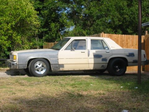 1985 Ford LTD Crown Victoria - This 1985 Ford Crown Victoria LTD shows its side profile, primer-gray front fenders and a beige body with various patches.