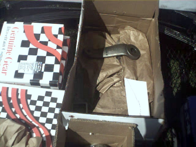 Metal automotive part in a cardboard box with packing paper