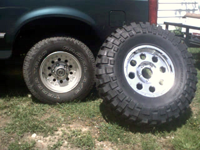 1996 Ford Bronco side view with one tire on and one off, showing off large off-road tires