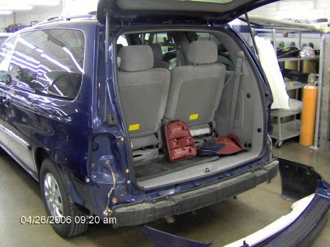 1999 Ford Taurus - The rear of a blue minivan is shown with its bumper removed and a taillight disassembled.
