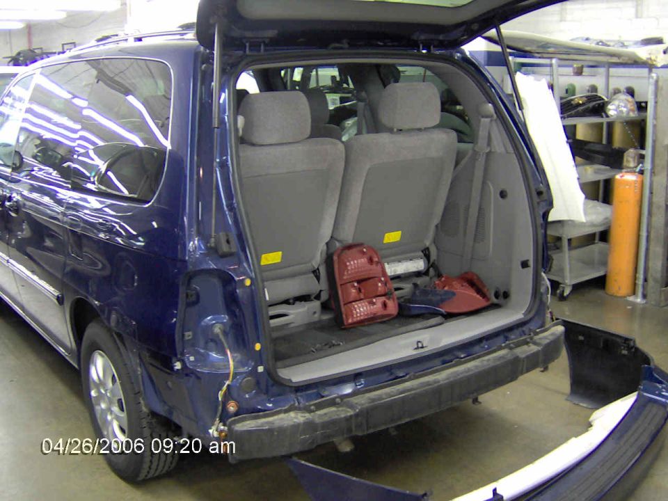Blue minivan, rear bumper off, taillight removed. Interior seats visible