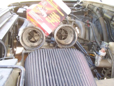 1994 Ford F-150 - Engine bay shot of a V8 fitted with a pair of vane-style intake swirl/tornado inserts clamped into short rubber intake tubes, sitting above…