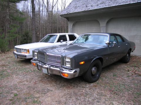1991 Ford LTD Crown Victoria - Two sedans are parked in front of a garage, one dark gray and the other white.