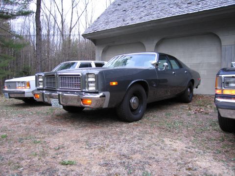 1991 Ford LTD Crown Victoria - Three sedans are parked in front of a garage. The closest is a 1977 Dodge Monaco.