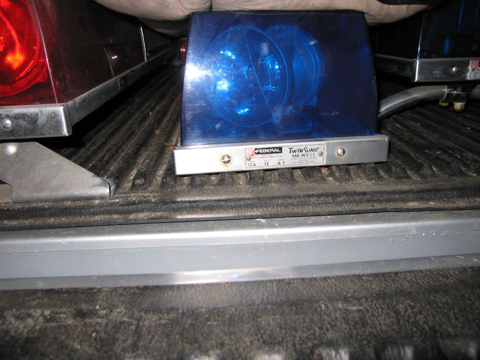Federal Twin Sonic blue emergency beacon light on a truck tailgate