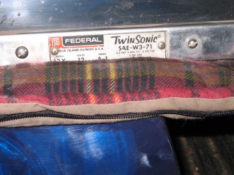 1991 Ford LTD Crown Victoria - Federal Twin Sonic SAE-W3-71 nameplate on a chrome beacon base, with a plaid blanket and blue light below.