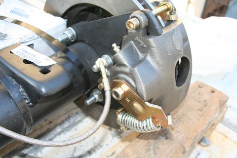 1992 Ford Bronco - Close-up of a vehicle's rear disc brake caliper and rotor assembly, with visible packaging and mounting hardware.