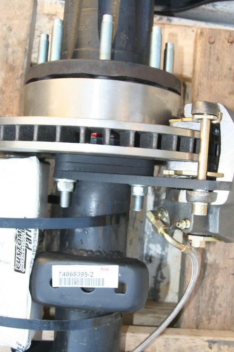 1992 Ford Bronco - A close-up view of a vehicle's rear axle disc brake assembly, showing the rotor and caliper mounting hardware.