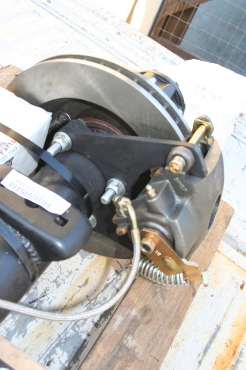 1992 Ford Bronco - A rear disc brake assembly is shown, mounted on wooden planks, with visible caliper, rotor, and bracket components.
