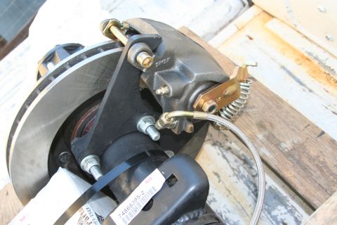 1992 Ford Bronco - A close-up view of a rear disc brake caliper and rotor assembly, with a part number visible on a tag.