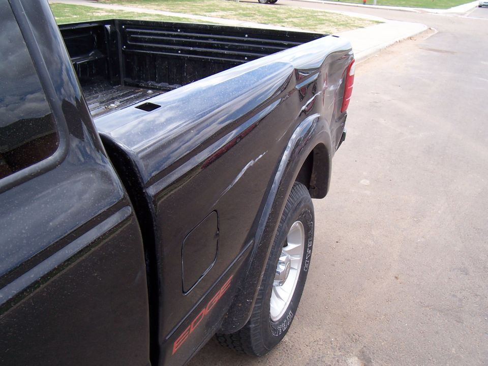 Black Ford Ranger pickup truck bed, side view. Red 'EDGE' decal visible on lower body panel