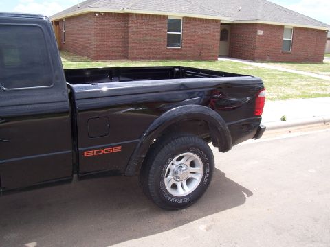2003 Ford Ranger - A black pickup truck is seen from the side, 'EDGE' badging on its rear quarter panel.