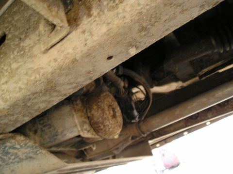 1991 Ford Explorer - Close-up view of the undercarriage of a vehicle, showing rusty parts and exhaust system.