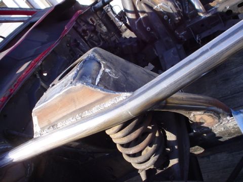 1968 Ford Torino - Close-up view of a custom roll cage and suspension system installed on a vehicle's chassis.