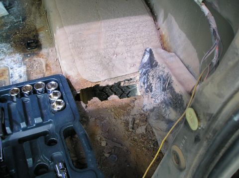 1991 Ford Explorer - Interior view of a heavily rusted vehicle with a hole in the floor exposing a tire.
