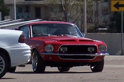 1972 Ford Ranchero - A red classic car is parked next to a white vehicle on a sunny day.