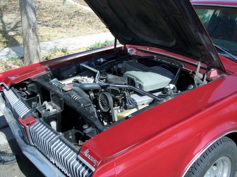 1972 Ford Ranchero - The engine bay of a red Mercury Cougar, identified by its distinctive grille and badging.