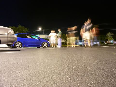 1994 Ford Probe - A blue hatchback is parked next to a silver car under a street light at night.
