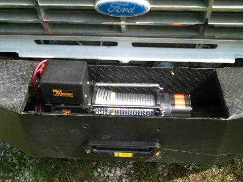 1986 Ford Bronco - A Mile Marker winch is mounted on a heavy-duty bumper, with the Ford logo visible on the grille above.