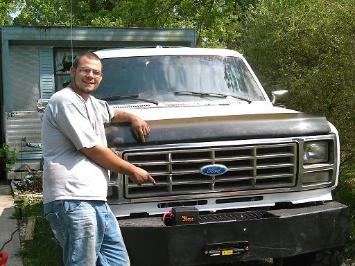 1986 Ford Bronco front view with winch plate bumper and man pointing at grille