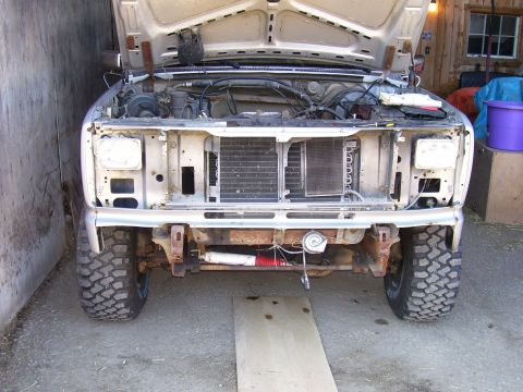 1984 Ford Bronco - The front end of a truck is disassembled, revealing the engine compartment and radiator.