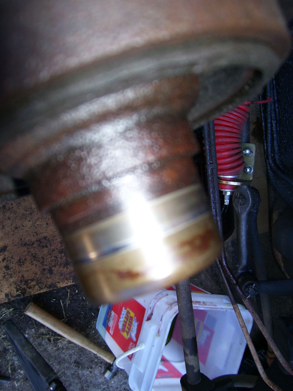 Close-up of a metal automotive part with brass-colored bands