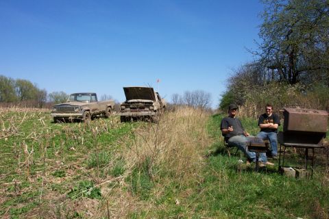1979 Ford F-150 - Two older trucks sit in a grassy field under a clear blue sky.