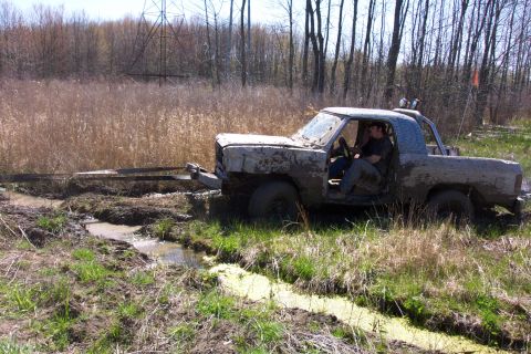 1979 Ford F-150 - A truck is stuck in the mud while off-roading in a wooded area.