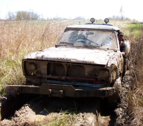 1979 Ford F-150 - This 1979 Dodge pickup truck is heavily covered in mud as it navigates a challenging off-road terrain.