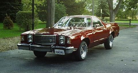 1972 Ford Ranchero - This 1972 Ford Ranchero is parked on a paved surface with trees and a fence in the background.