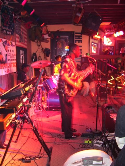 1994 Ford Probe - A band plays music on a stage, with a guitarist in the foreground and drums and keyboards visible.