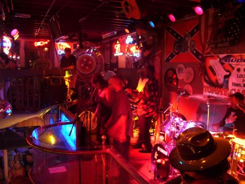 1994 Ford Probe - A band plays live music in a bar decorated with flags and signs.