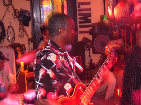 1994 Ford Probe - A band performs live music in a bar setting, illuminated by red stage lights.