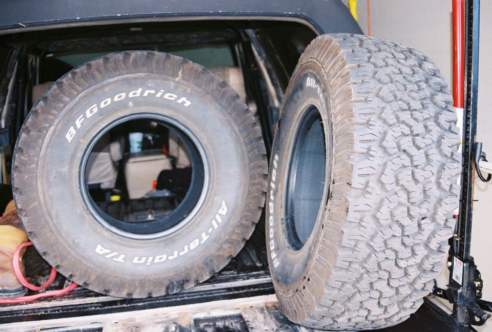 Two BFGoodrich All-Terrain T/A tires in the cargo area of a vehicle