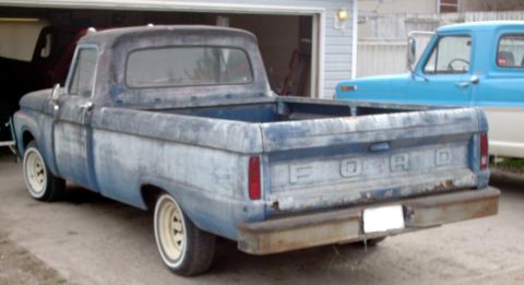 1965 Ford F-100 - This blue Ford pickup truck has a weathered finish and appears to be from the late 1960s.