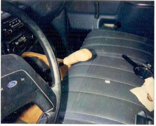Interior shot of a vehicle showing the steering wheel, dashboard, and a shifter knob on the passenger seat