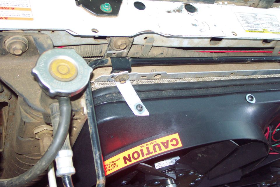 Top Mounting Brackets
The top mounting brackets hold the shroud against the radiator core but do not carry any weight and are made of 1/16 x 3/4 aluminum flat stock.
Did not use any of the manufactures supplied mounting bracketry.
(4/29/2006)