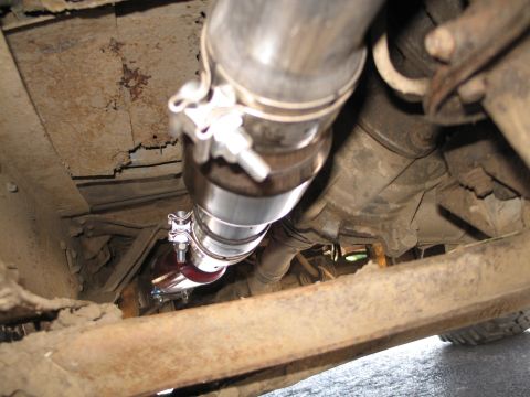 1995 Ford Bronco - Close-up of a vehicle's exhaust system, showing a catalytic converter and clamps.