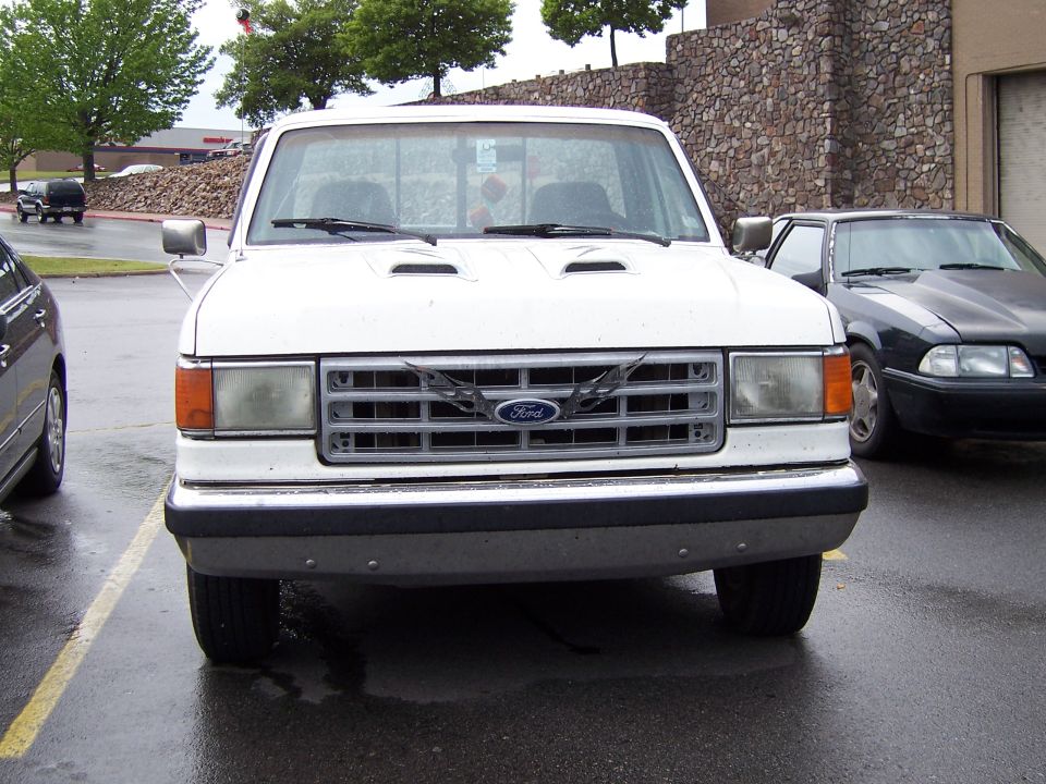 White Ford F-Series truck front view, with aftermarket hood scoops and a custom grille emblem