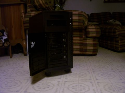 1994 Ford Probe - A dark computer tower with its front door ajar is shown in a room with plaid furniture.