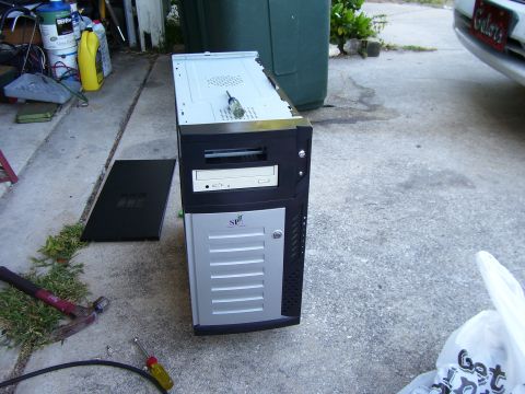 1994 Ford Probe - A computer tower sits on a concrete surface, accompanied by a hammer and screwdriver, suggesting a repair or assembly task.