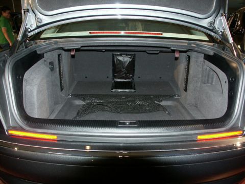 2001 Mercury Grand Marquis - The trunk of a car is shown with a cargo net and a black bag. A person is visible in the background.