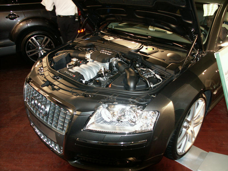 Dark grey Audi S8 with hood open, showing engine and front grille
