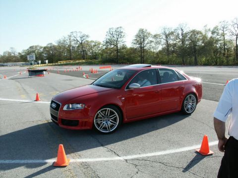 2001 Mercury Grand Marquis - A red sedan navigates a course marked by orange cones on a sunny day.