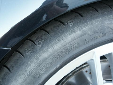 2001 Mercury Grand Marquis - Tire shows significant wear and damage to the tread blocks.